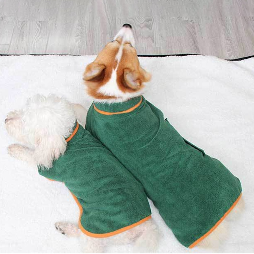 Two dogs wearing a Dog Bathrobe, a soft absorbent towel for pets, relaxing on a blanket.